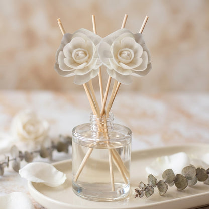 Reed diffuser bottle with reeds, in earthy forest-inspired scents