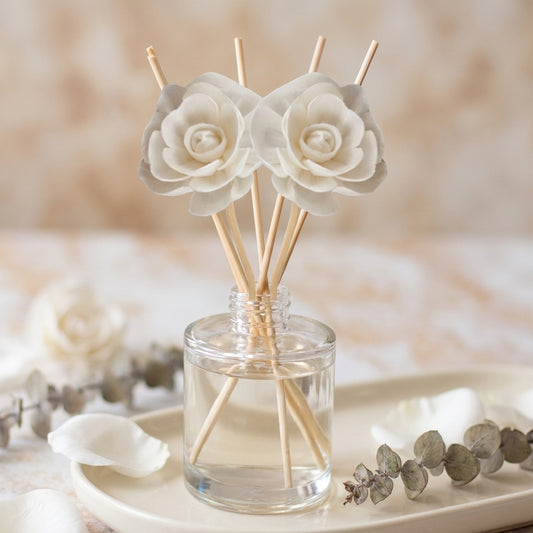 Reed diffuser bottle with reeds, in earthy forest-inspired scents