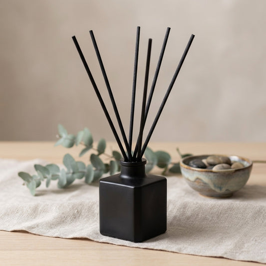 Reed diffuser bottle with reeds, in deep wood, smoke and mineral scents